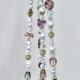 A close-up highlighting the heirloom-quality beads with heart and floral details on the Antique Garden hanger.