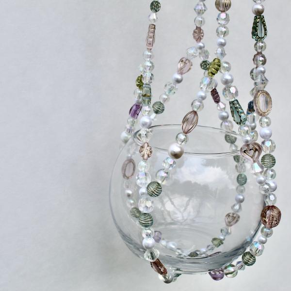 A soft-focused image showing the delicate fusion of soft greens and neutral tones in the Antique Garden beaded hanger.