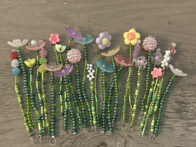 A colorful, handmade beaded flower magnet adding a pop of charm to a kitchen fridge.