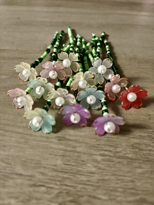 A charming beaded flower bouquet magnet used as a decorative office supply on a magnetic board.