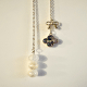 Close-up detail shot of the Moon Bow and Clover Charm.