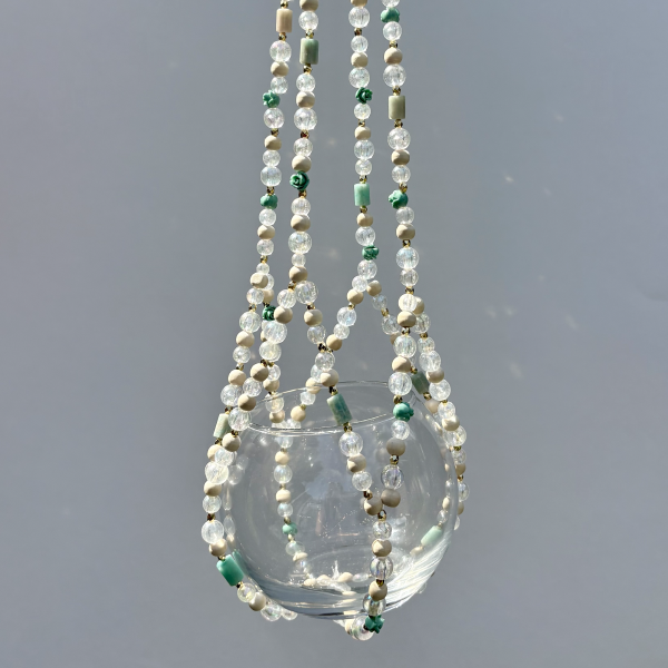 A macro shot of the mixed textures, including matte wood-like beads and tiny green rose details.